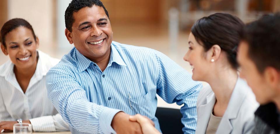 Two people shaking hands in a meeting